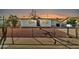 Ranch style home at sunset with brick veneer, chain link fence and low maintenance yard at 7113 E Bell Cir, Mesa, AZ 85208