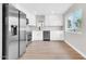 Bright kitchen with stainless steel appliances and white cabinetry, complemented by wood flooring at 7113 E Bell Cir, Mesa, AZ 85208