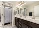 Bathroom with dual sinks, wood cabinets, tiled floor and shower with curtain at 7337 S Debra Dr, Gilbert, AZ 85298