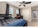 Comfortable bedroom featuring a bed, desk, ceiling fan, and generous natural light from large windows at 7337 S Debra Dr, Gilbert, AZ 85298