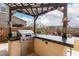 Outdoor kitchen features a built-in grill, bar seating, and a pergola for shade at 7337 S Debra Dr, Gilbert, AZ 85298