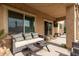 Inviting covered patio featuring a cushioned couch, decorative pillows, and a stylish outdoor coffee table at 7337 S Debra Dr, Gilbert, AZ 85298