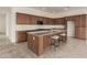 Well-equipped kitchen featuring a central island with seating, dark wood cabinets and tile flooring at 742 E Watermelon Ln, Queen Creek, AZ 85140