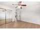 Bedroom with hard wood flooring, a mirrored closet, and a ceiling fan at 7458 E Clovis Cir, Mesa, AZ 85208