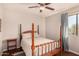 Bright bedroom featuring a four-poster bed, ceiling fan, and a sunny window at 8612 N 31St Ln, Phoenix, AZ 85051