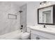 This bathroom is updated with a white vanity and a tub-shower combo with a tiled accent wall at 8826 W Amelia Ave, Phoenix, AZ 85037