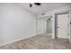 This bedroom features wood-look tile flooring, a ceiling fan, and a closet with mirrored sliding doors at 8826 W Amelia Ave, Phoenix, AZ 85037