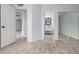 A bedroom with a view into the bathroom, light colored wood look floors, and white doors at 8826 W Amelia Ave, Phoenix, AZ 85037