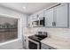 A well-lit kitchen features stainless steel appliances, light countertops, and grey cabinets at 8826 W Amelia Ave, Phoenix, AZ 85037