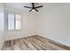 Bright bedroom with wood floors, white walls, ceiling fan and a window with plantation shutters at 10243 N 103Rd St, Scottsdale, AZ 85258