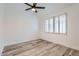 Bright bedroom with wood floors, white walls, ceiling fan and a window with plantation shutters at 10243 N 103Rd St, Scottsdale, AZ 85258