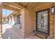 Inviting front porch featuring decorative stonework, decorative security door, and a cozy sitting area at 10243 N 103Rd St, Scottsdale, AZ 85258