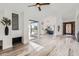 Bright, open-concept living room with modern fireplace, hardwood floors, and sliding glass doors to the patio at 10243 N 103Rd St, Scottsdale, AZ 85258