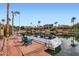 Picturesque waterfront view featuring a private dock with seating and boat, surrounded by lush landscaping and elegant homes at 10243 N 103Rd St, Scottsdale, AZ 85258