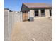 A fenced gravel backyard with a patio and air conditioner unit at 1061 W Palo Verde Ave, Coolidge, AZ 85128