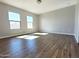 An airy bedroom is illuminated by sunlight streaming through two windows and features sleek, wood-look flooring at 1061 W Palo Verde Ave, Coolidge, AZ 85128