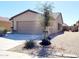 A single-story home with a tile roof, desert landscaping, and a two car garage on a sunny day at 1061 W Palo Verde Ave, Coolidge, AZ 85128