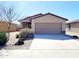 A single-story home with desert landscaping and a two car garage on a sunny day at 1061 W Palo Verde Ave, Coolidge, AZ 85128