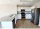 Modern kitchen featuring white cabinets, stainless steel appliances, and granite countertops, illuminated by overhead lighting at 1061 W Palo Verde Ave, Coolidge, AZ 85128