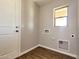 A clean and functional laundry room includes hookups, a window for ventilation, and access door at 1061 W Palo Verde Ave, Coolidge, AZ 85128