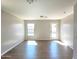 A bright living room with natural light, wood-look floors, and neutral-colored walls leading to outdoor patio access at 1061 W Palo Verde Ave, Coolidge, AZ 85128