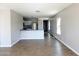 An open concept living space with plank flooring, large windows for natural light, and a kitchen in the background at 1061 W Palo Verde Ave, Coolidge, AZ 85128