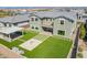 Aerial view of a backyard oasis featuring lush green lawn, fire pit, patio, and covered outdoor living space at 10635 E Tesla Ave, Mesa, AZ 85212