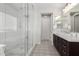 Bathroom featuring a glass-enclosed shower and vanity with decorative patterned tile flooring at 10635 E Tesla Ave, Mesa, AZ 85212