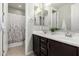 Modern bathroom with a double sink vanity, stylish mirrors, and a shower with a patterned curtain at 10635 E Tesla Ave, Mesa, AZ 85212