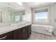 Stylish bathroom showcasing a freestanding tub, patterned tile floor, and a glass-enclosed shower at 10635 E Tesla Ave, Mesa, AZ 85212