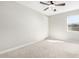 Airy bedroom featuring neutral paint, carpet, and ceiling fan, bathed in natural light through a large window at 10635 E Tesla Ave, Mesa, AZ 85212