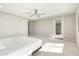 Bright bedroom with a ceiling fan and a door leading to outdoor space, filled with natural light at 10635 E Tesla Ave, Mesa, AZ 85212