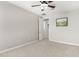 Large carpeted bedroom with a ceiling fan and an open door that shows the view of another room at 10635 E Tesla Ave, Mesa, AZ 85212