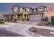 Elegant two-story home with a well-manicured front yard under a colorful sunset sky at 10635 E Tesla Ave, Mesa, AZ 85212