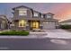 Elegant two-story home with a well-manicured front yard under a colorful sunset sky at 10635 E Tesla Ave, Mesa, AZ 85212