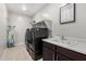 Well-organized laundry room featuring modern appliances, a utility sink, and ample shelving at 10635 E Tesla Ave, Mesa, AZ 85212