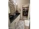 Stylish bathroom with stone accent wall, dual sinks and a door opening to a walk-in closet at 10655 N 9Th St # 204, Phoenix, AZ 85020