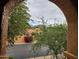 Exterior view of a home's charming facade, beautifully framed by an archway and lush greenery at 10655 N 9Th St # 204, Phoenix, AZ 85020