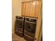 Laundry room with modern gray washer and dryer, with wood cabinets above at 10655 N 9Th St # 204, Phoenix, AZ 85020