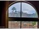 Framed scenic hillside view with palm trees and architecture from an arched window at 10655 N 9Th St # 204, Phoenix, AZ 85020