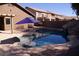 Refreshing backyard pool with umbrella, rock features and lush desert landscaping at 1083 E Jade Dr, Chandler, AZ 85286