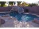 Inviting pool features rock waterfall, and a slide perfect for summer fun in the backyard at 1083 E Jade Dr, Chandler, AZ 85286