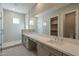 Modern bathroom with double sinks, sleek countertops, and a glass-enclosed shower showcases contemporary style and functionality at 10972 N Hershey St, Surprise, AZ 85388