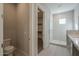 Well-lit bathroom featuring decorative tile flooring, walk-in shower, and a door to the closet at 10972 N Hershey St, Surprise, AZ 85388