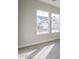 Sunlit bedroom featuring a pair of windows and gray flooring at 10972 N Hershey St, Surprise, AZ 85388