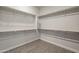 Spacious walk-in closet with gray wood floors and white shelving all around at 10972 N Hershey St, Surprise, AZ 85388