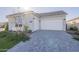 Modern home features a two-car garage and stylish paver driveway, set against a sunny sky at 10972 N Hershey St, Surprise, AZ 85388