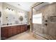 Beautiful bathroom featuring dual vanities, granite countertops, and a tiled walk-in shower with glass surround at 11122 N 165Th Ave, Surprise, AZ 85388