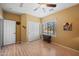 Cozy bedroom with laminate floors, a ceiling fan, closet, and natural light from the window at 11122 N 165Th Ave, Surprise, AZ 85388