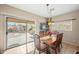 Dining room features a view to a patio and outdoor fireplace, with a light fixture, and a dining table at 11122 N 165Th Ave, Surprise, AZ 85388